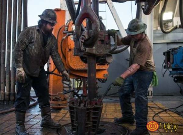 Рабочие добывают нефть