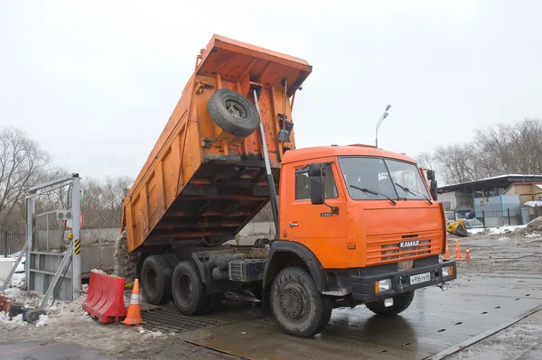 Оранжевый автомобиль-самосвал КАМАЗ - 65115 о negotable точке таяния снега, Москва — стоковое фото