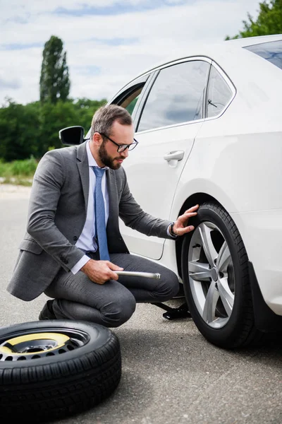 Handsome Businessman Changing Tires Car Road — стоковое фото