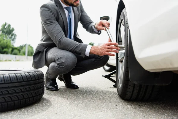 Cropped Image Businessman Changing Tires Car Road — стоковое фото